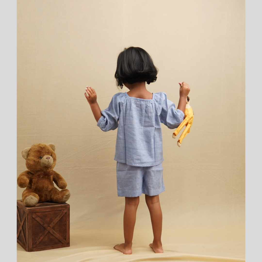 Girl wearing Top and shorts set in pure cotton and showing the backside of the attire