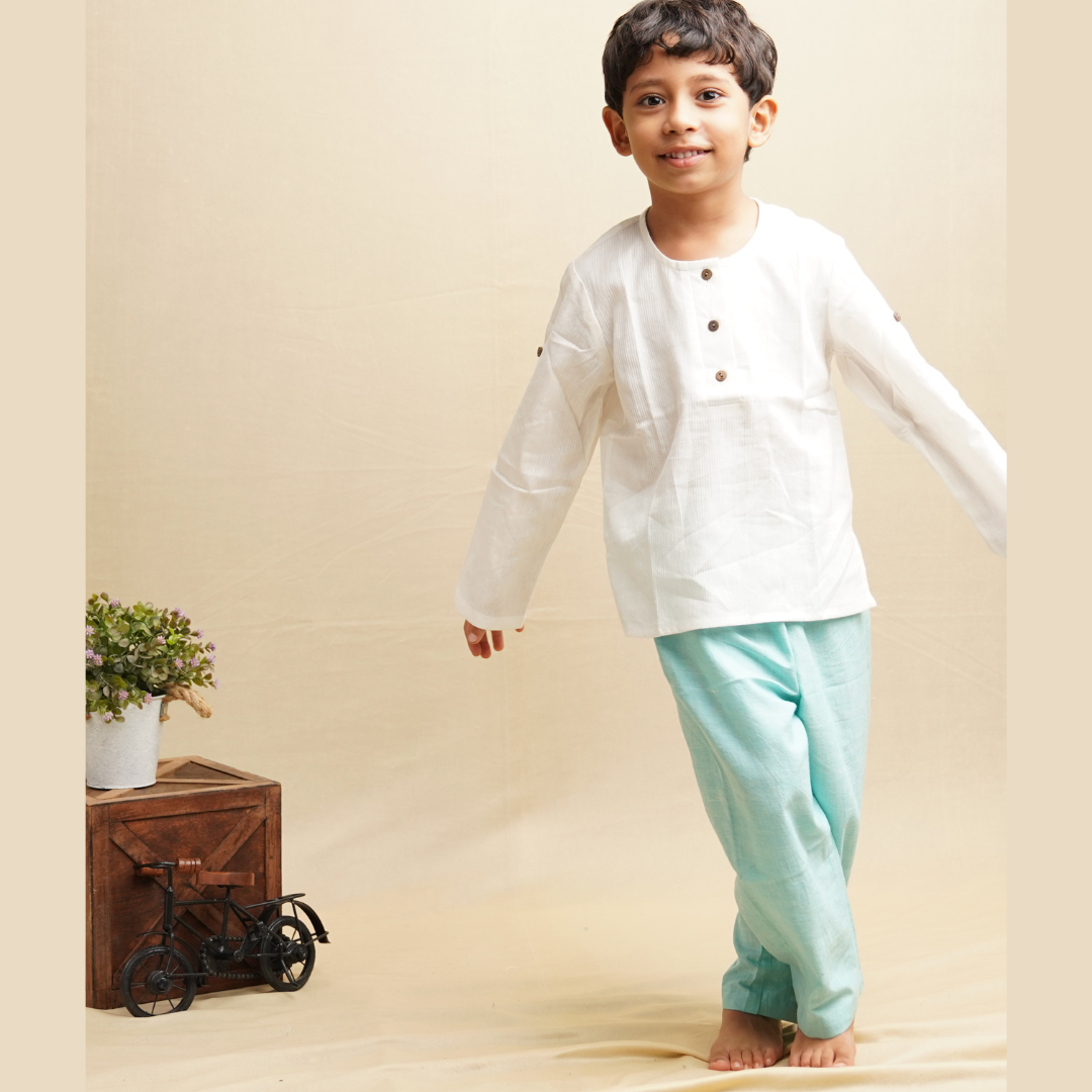 Boy wearing Khadi full sleeve shirt and pants standing against beige background