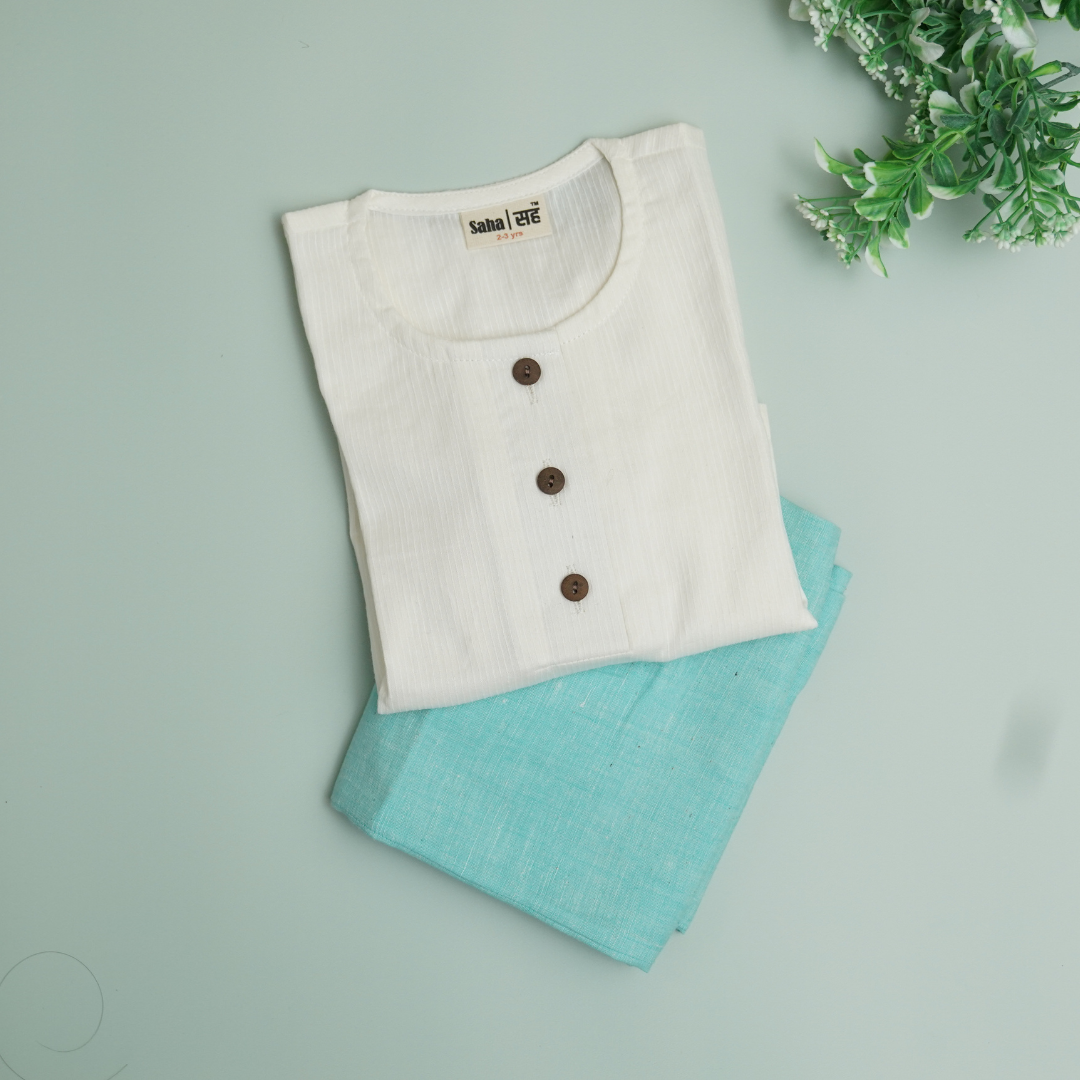 White shirt with brown buttons and turquoise pants on a light green background