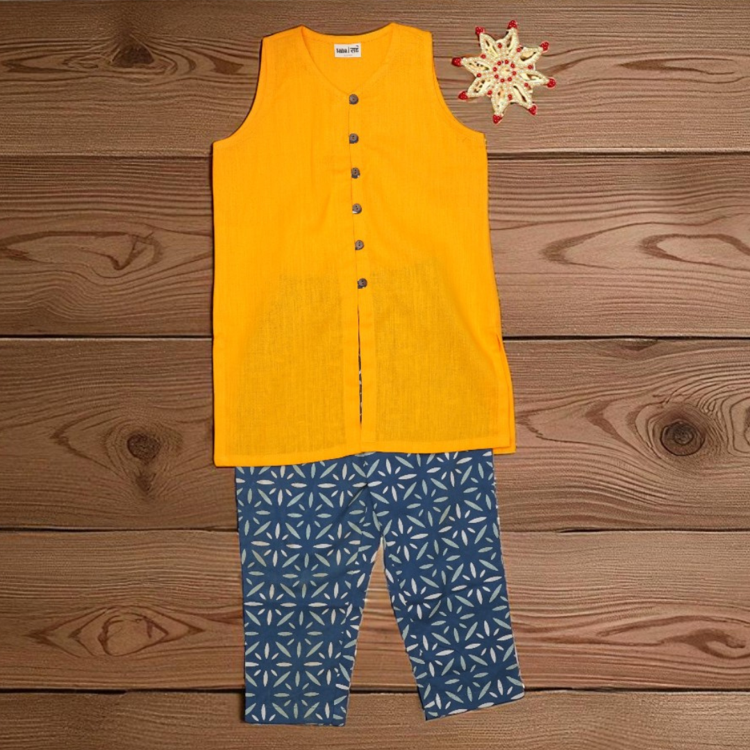 Yellow sleeveless top and blue patterned pants on a wooden surface