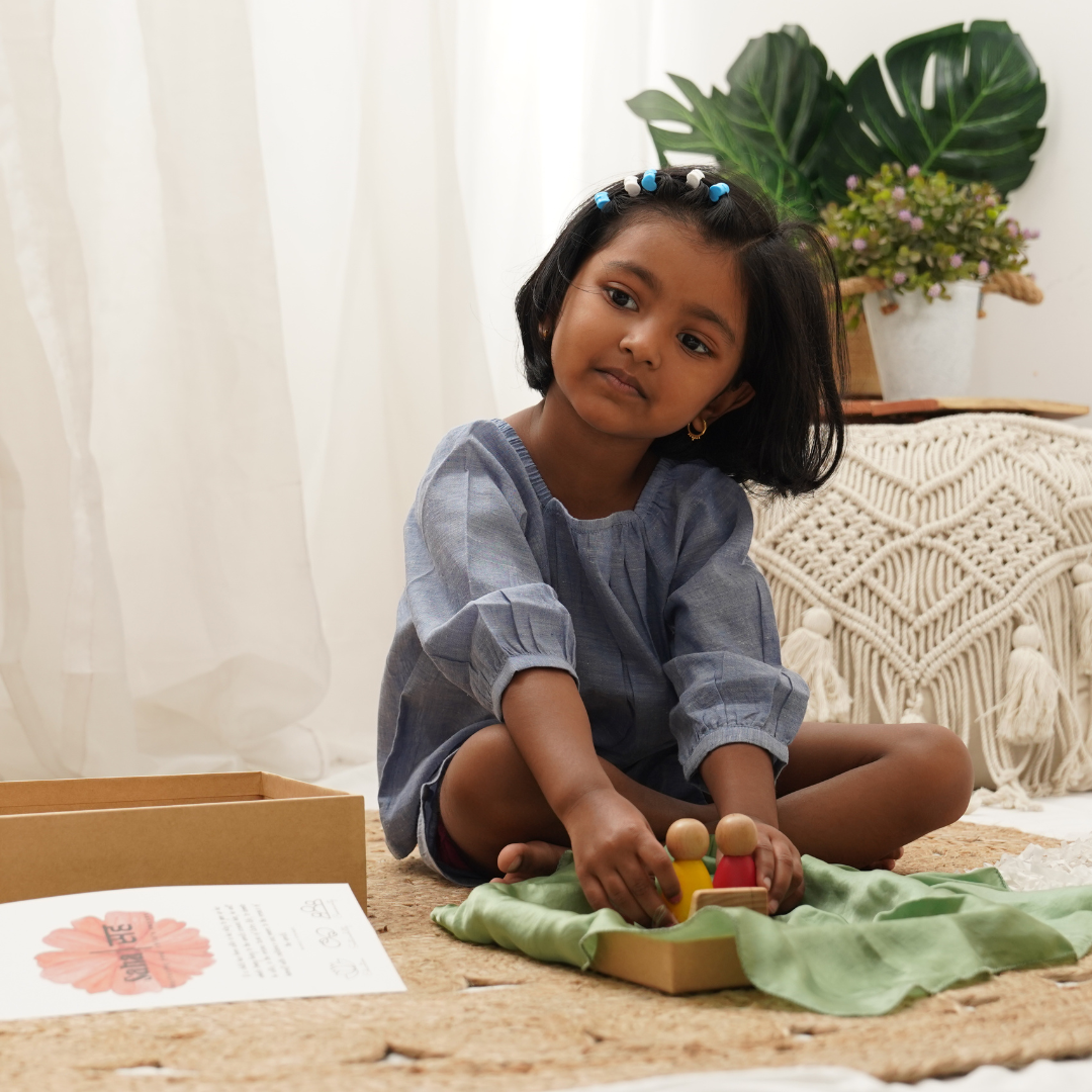 Girl wearing cotton top and shorts set and playing with wooden toys