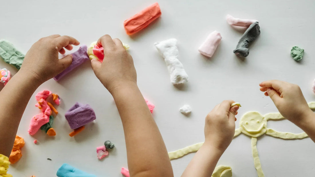 Children playing with colorful modeling clay, creating shapes for sensory learning