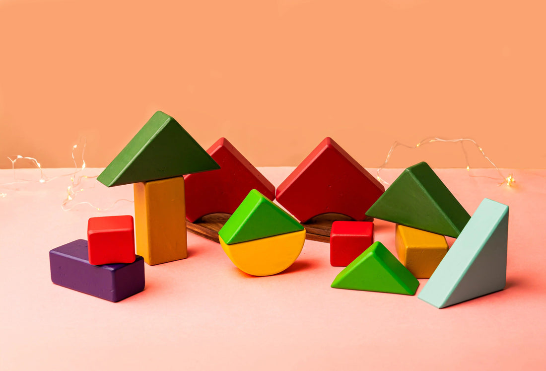 Colorful wooden building blocks and educational toys on a peach background
