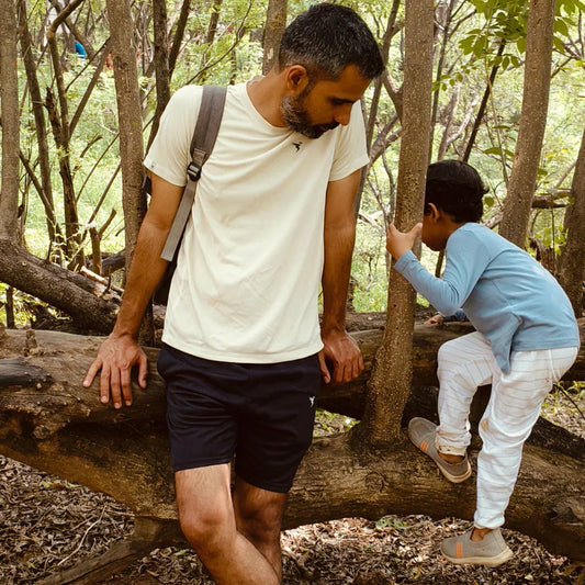 Father and child exploring outdoors, wearing casual cotton clothes in a forest setting
