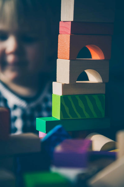 Child playing with colorful wooden building blocks, Montessori educational toy
