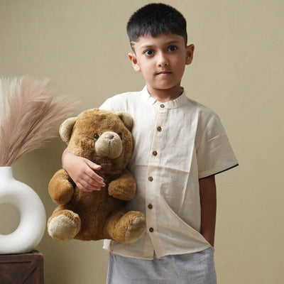 Boy in organic cotton khadi shirt holding teddy bear, sustainable kids clothing