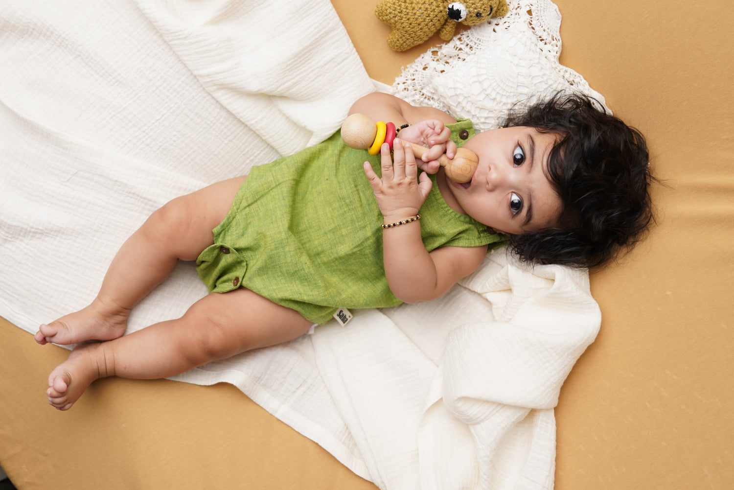 Infant playing with wooden rattle