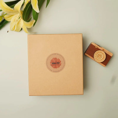 Eco-friendly gift box with wooden toy camera and yellow lilies, sustainable toy packaging
