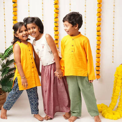 Kids in pure cotton clothes: yellow tunics, printed pants, and flowy skirts for free play and comfort
