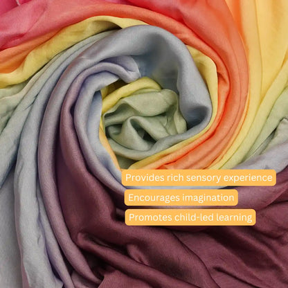 Close-up of soft rainbow semi-giant playsilk showing silky texture and pastel rainbow colors for sensory and imaginative play