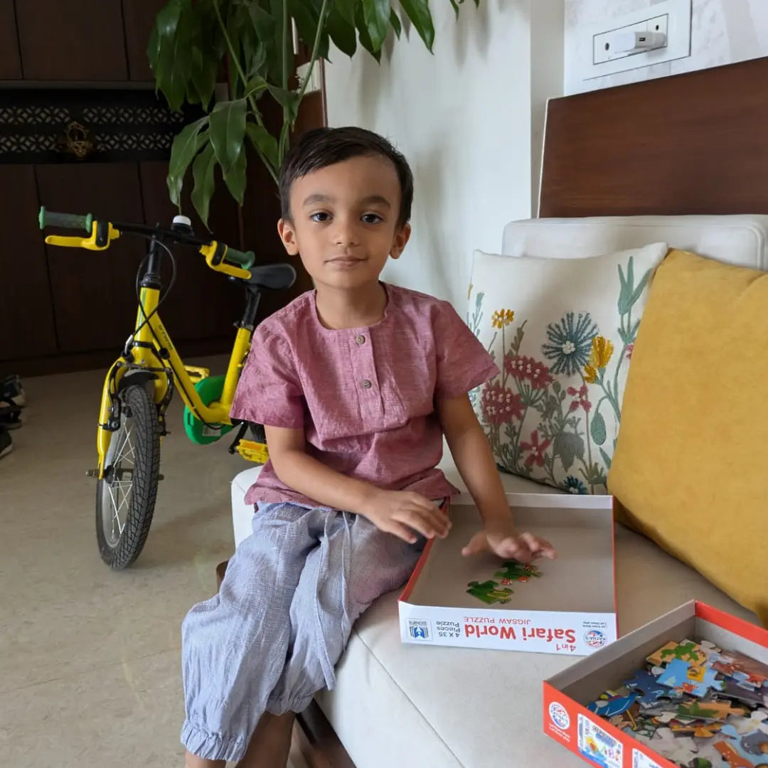 Child wearing cotton kurta and pants sitting on a couch 