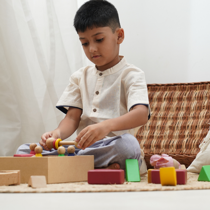 Boy wearing Khadi Shirt and playing with open-ended wooden toys