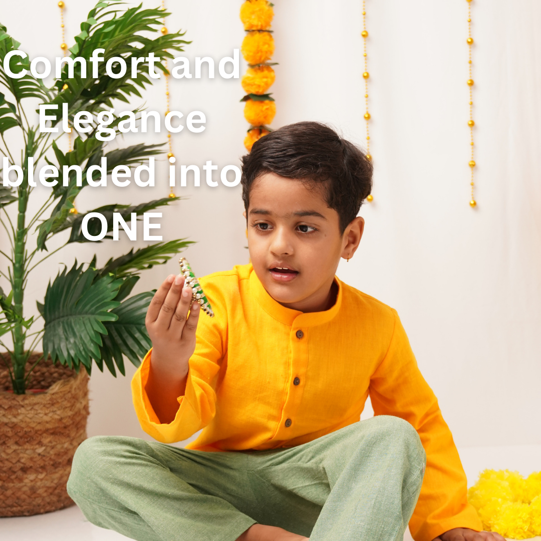 Child in a yellow Kurta and green pants sitting on the floor with decorative elements in the background.