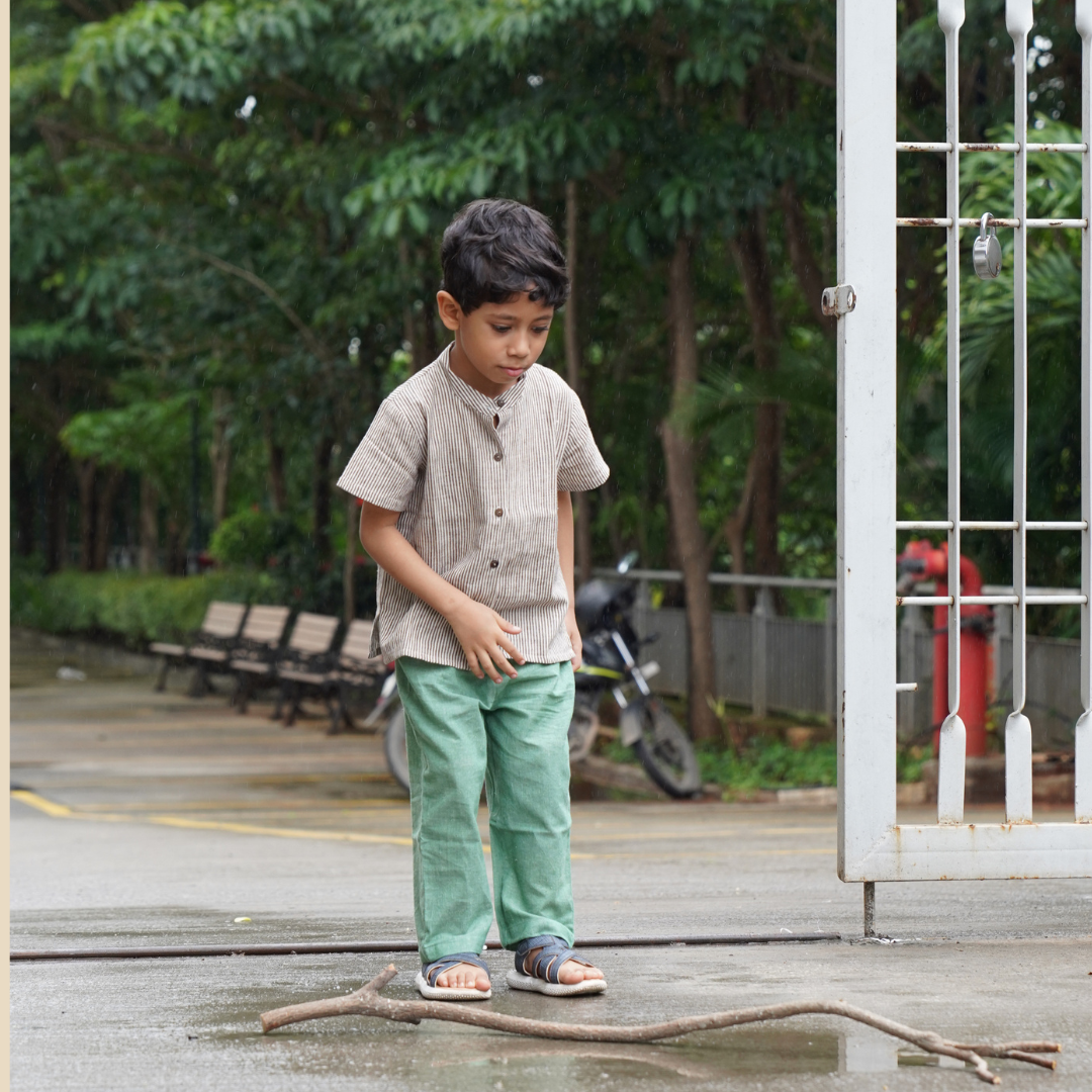 Boy wearing comfortable khadi shirt and pants and playing outdoors
