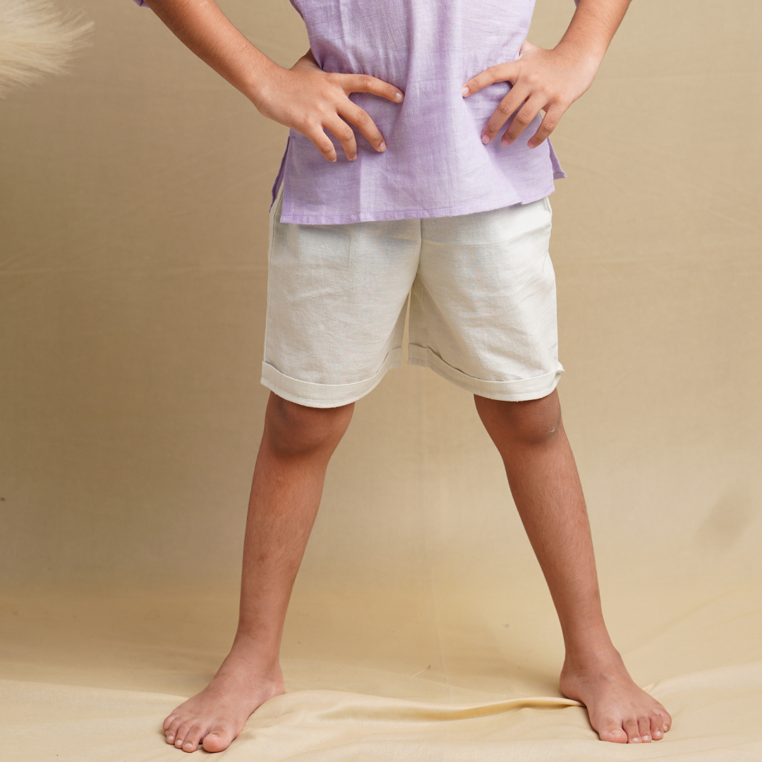 A pair of beige Terra Trotters boys' shorts in pure cotton displayed on a model, showcasing the fit and style of the shorts.