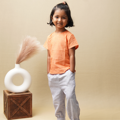 Girl in comfortable khadi top and bottom set standing against a beige background