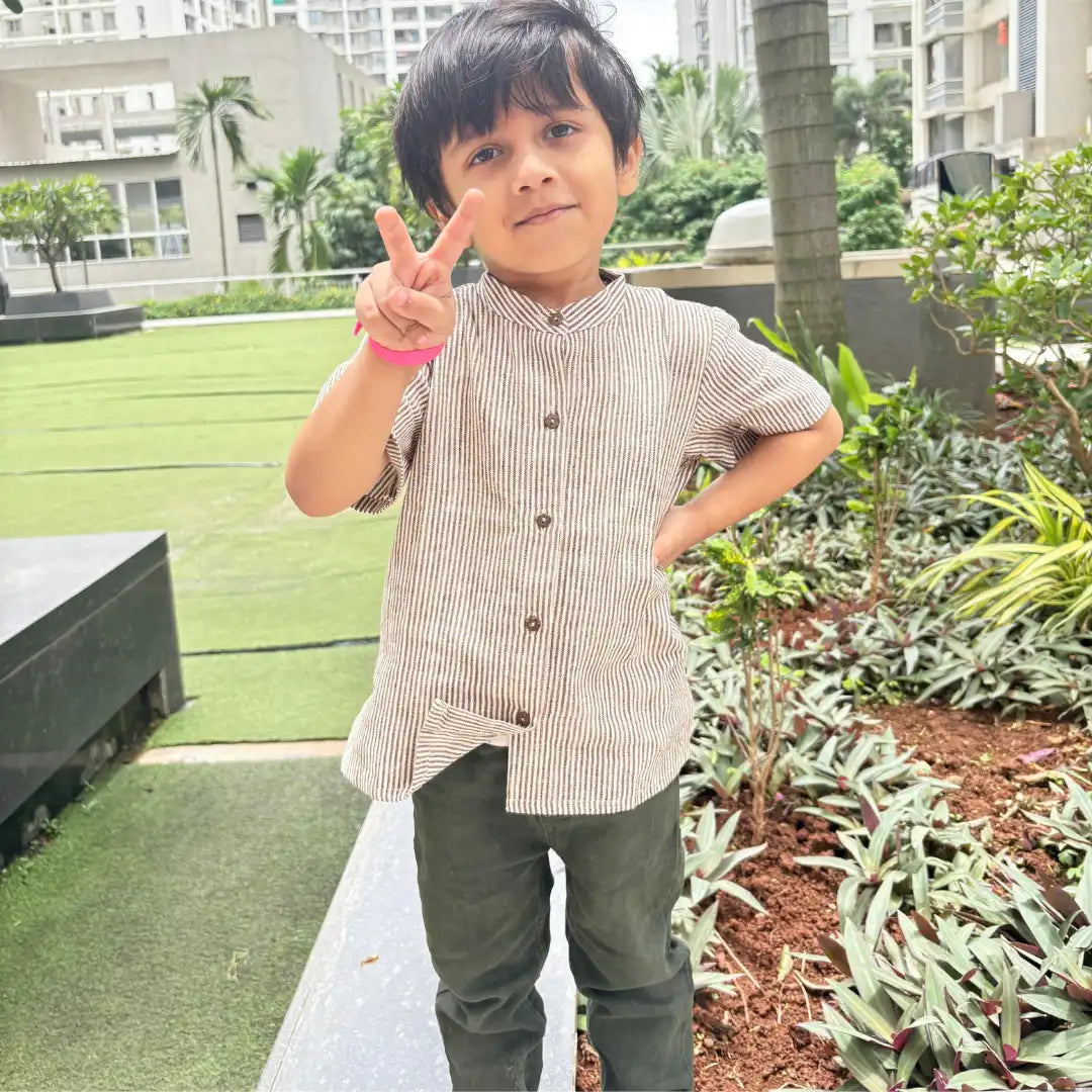 Boy wearing stripe cotton shirt standing outdoors
