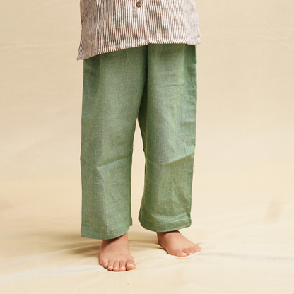 Green pants worn by a child on a beige background