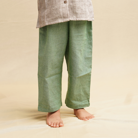 Green pants worn by a child on a beige background