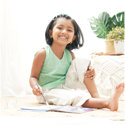 Girl similing wearing pure cotton casual outfit top and bottom holding a brush in her hands