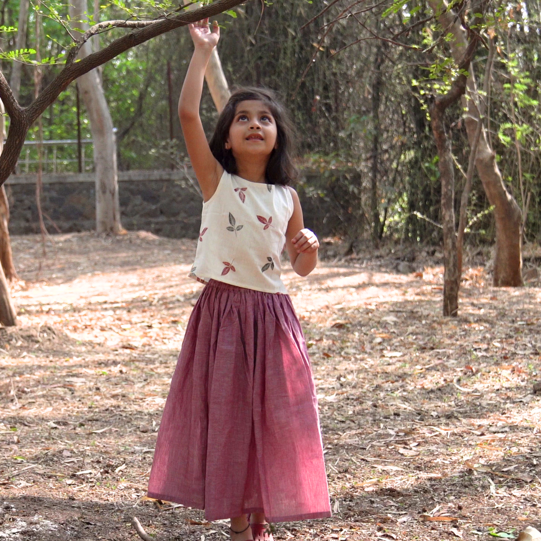 Girl wearing crop top and skirt festive wear set and playing outdoors
