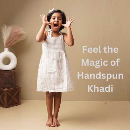 Young girl in a white dress in pure cotton with text 'Feel the Magic of Handspun Khadi' on a beige background