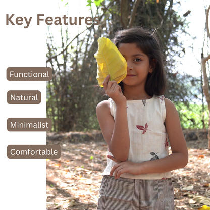 Child wearing Khadi clothes holding a yellow leaf outdoors with text 'Key Features' on the left.