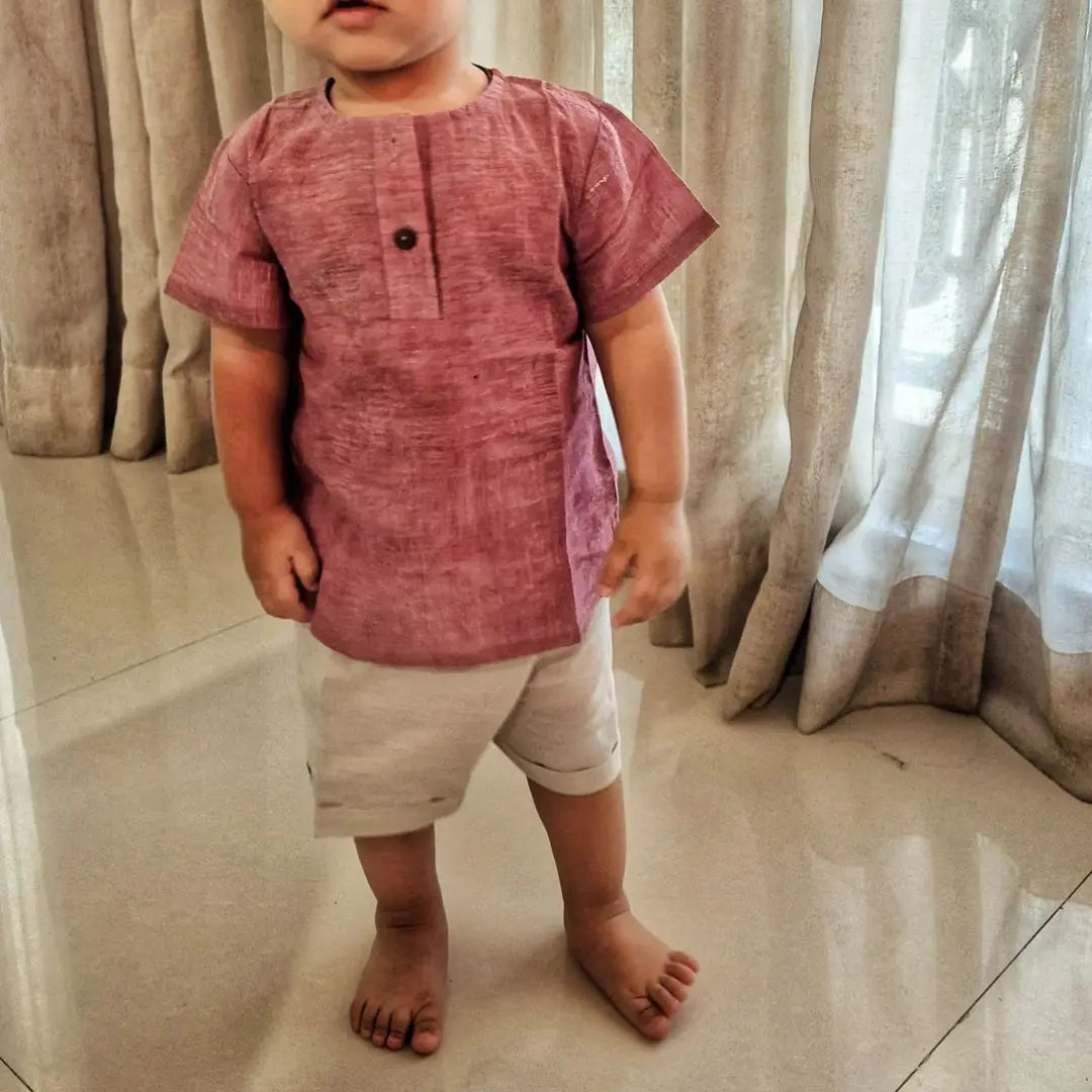Child wearing a light red shirt and light grey in khadi 