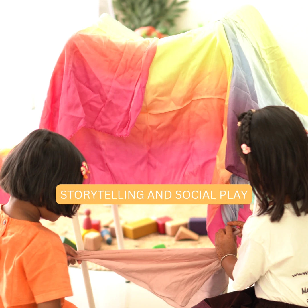 Children building a colorful fort using a soft rainbow semi-giant playsilk for storytelling and social play activities