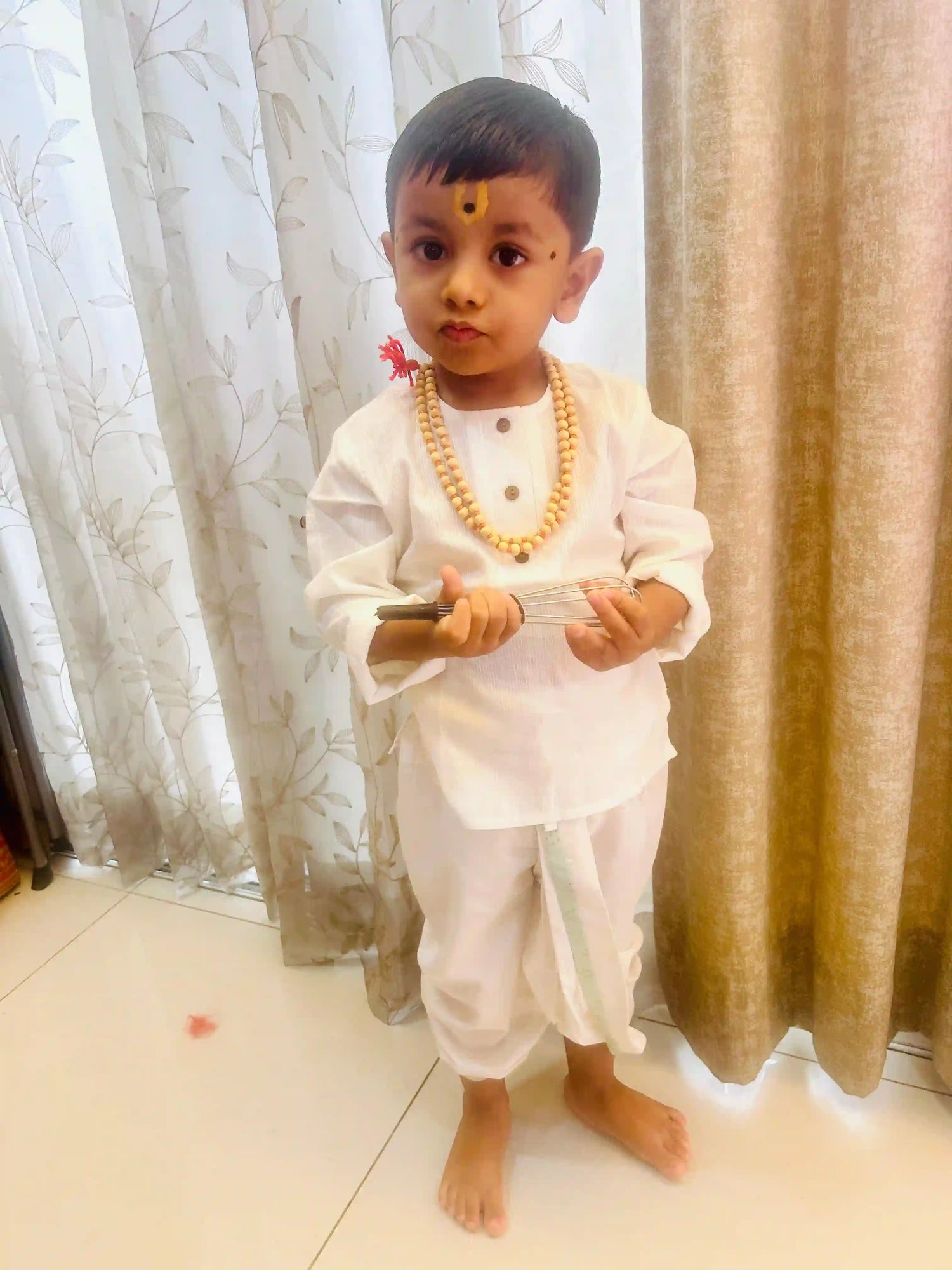 Child in white cotton kurta standing 
