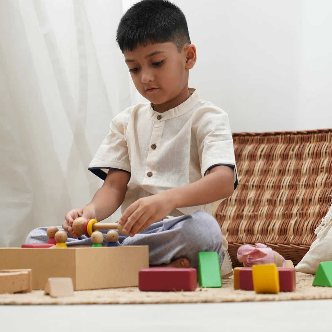 Boy wearing a jogger and shirt set while playing with wooden toys