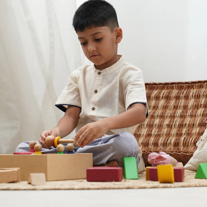 Boy wearing a jogger and shirt set while playing with wooden toys