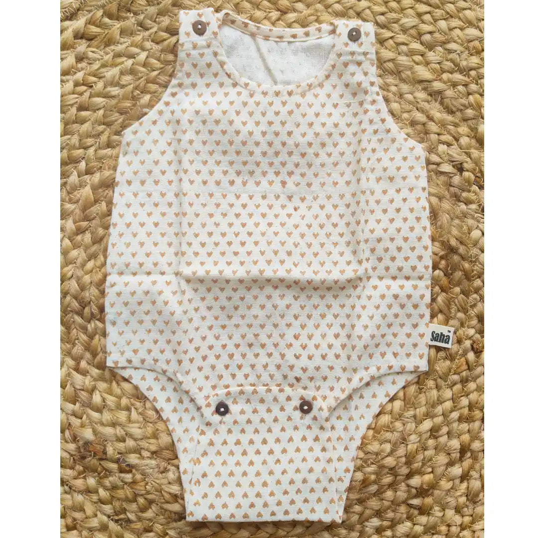 Flat lay of the unisex baby Romper in handspun khadi fabric with tiny heart prints and snap buttons for easy diaper changes
