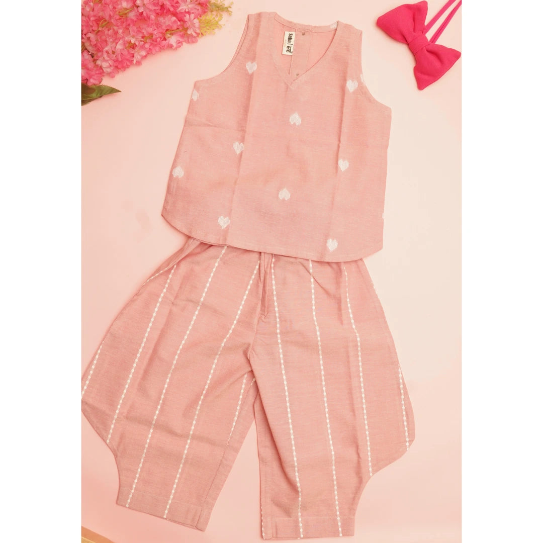 Flat lay of pink handloom cotton coord set with sleeveless heart-print top and relaxed striped pants for girls.