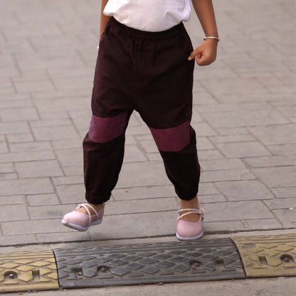 Child wearing dark khadi unisex joggers with knee patches and elastic ankles while walking outdoors
