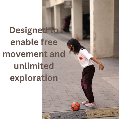 Girl playing outdoors in movement-friendly unisex joggers made from soft handspun khadi cotton.