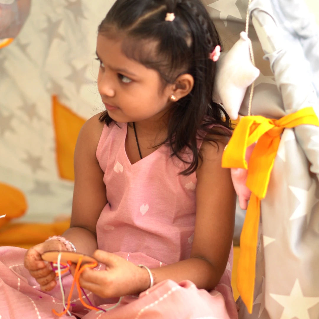 Girl sitting and playing in a soft pink sleeveless cotton coord set designed for comfort and easy movement