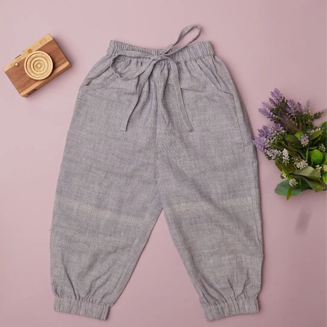 Flat lay of light purple cotton joggers for kids with drawstring waist, pockets and elasticated cuffs
