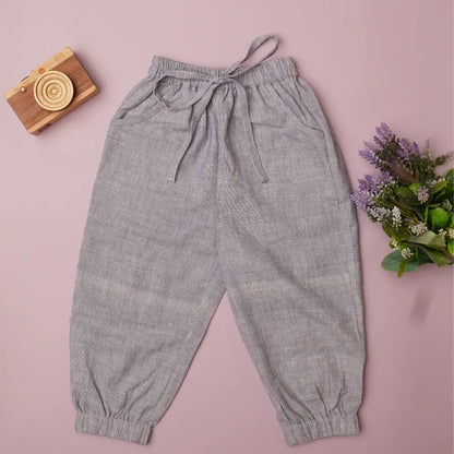 Flat lay of light purple cotton joggers for kids with drawstring waist, pockets and elasticated cuffs