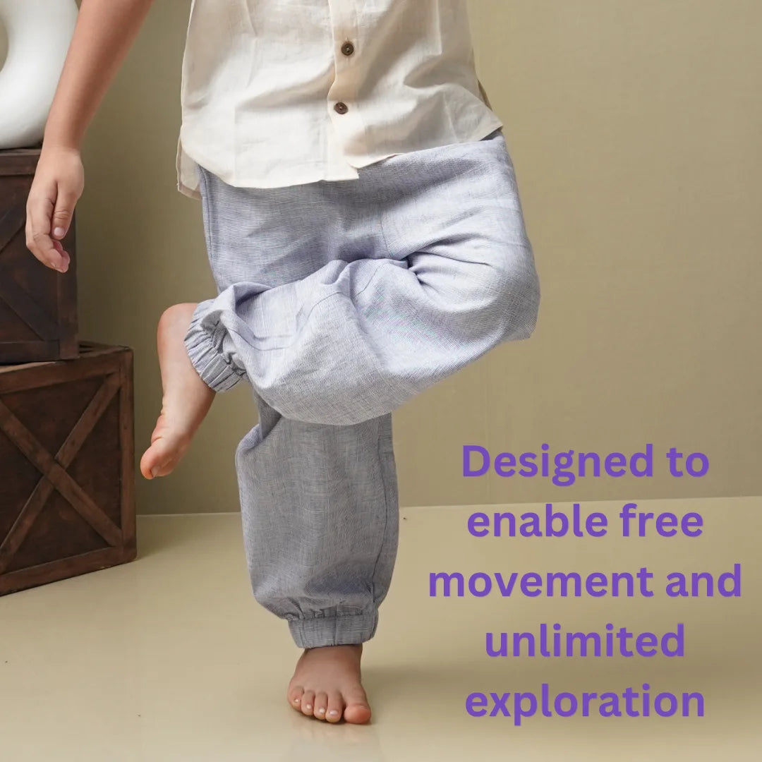 Child lifting one knee in light purple cotton joggers, designed to enable free movement and exploration