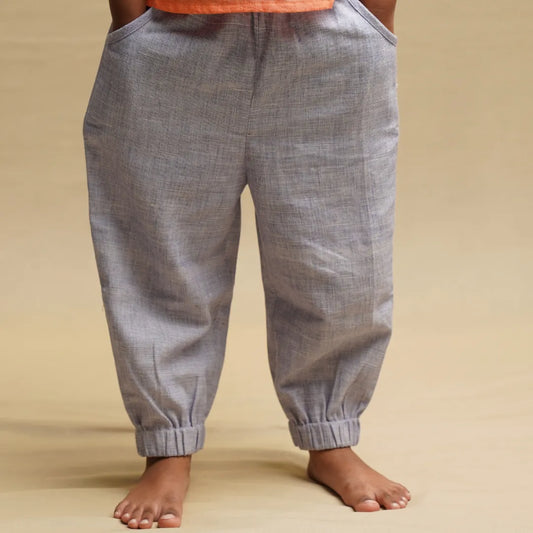 Front view of light purple handwoven cotton joggers for kids with side pockets and elasticated ankle cuffs