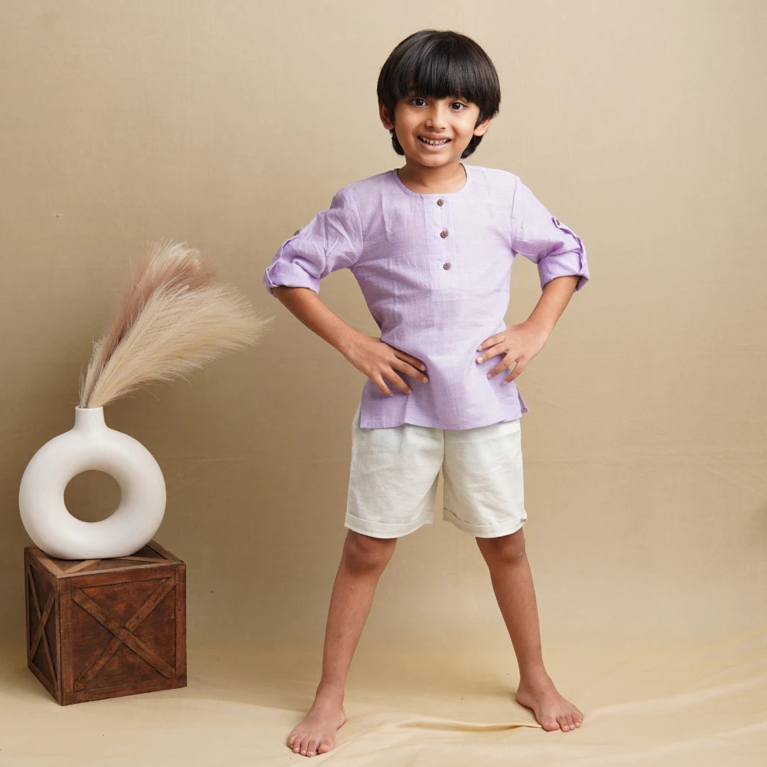 Child in light purple cotton kurta with roll-up sleeves and white shorts, hands on hips