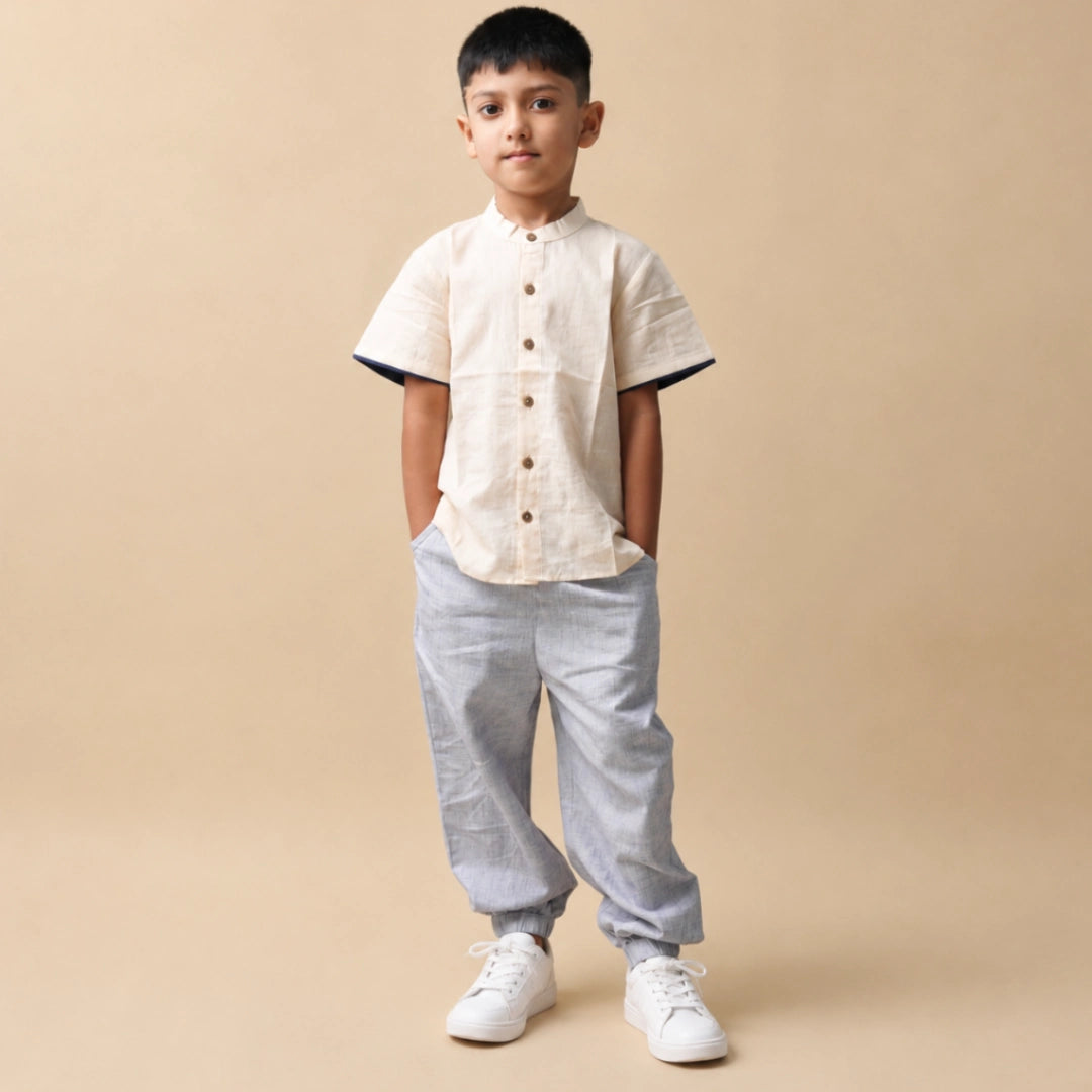 Boy in light purple unisex cotton joggers, cream button-down shirt and white sneakers