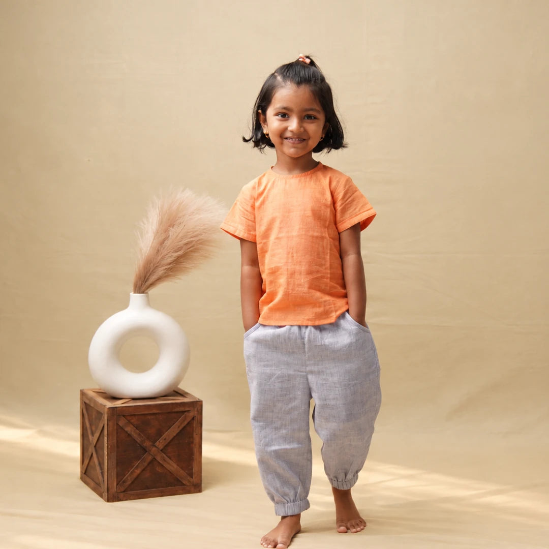 Smiling girl in light purple unisex cotton joggers and an orange cotton top