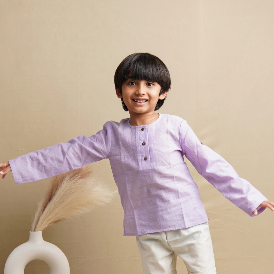 Smiling child with arms outstretched in a light purple full sleeve unisex cotton kurta with wooden buttons