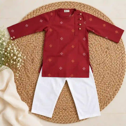 Flat lay of a maroon full sleeve kurta with gold and white motifs and four buttons beside a white pajama
