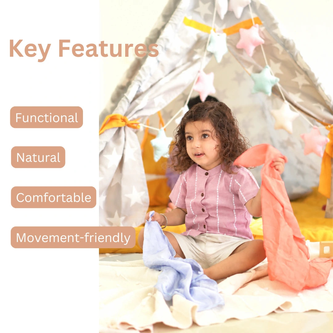 Child in a mauve cotton shirt playing with silk cloths in a play tent, with key features listed: functional, natural, comfortable, movement-friendly