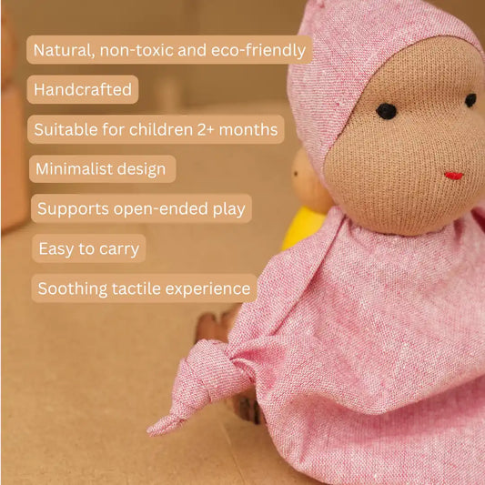 Close-up of a pink Waldorf-inspired baby cuddle doll made with natural fabric, featuring a minimalist design and soft, tactile texture.