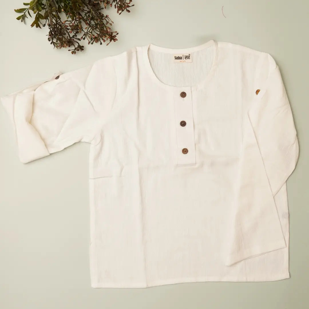 White long-sleeve shirt with brown buttons on a light green background