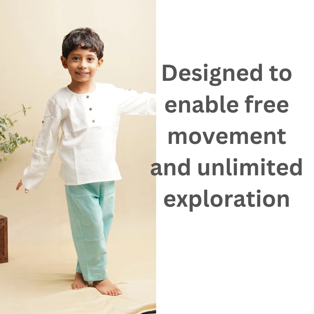 Smiling child in teal blue cotton pants and white kurta, designed for free movement and exploration